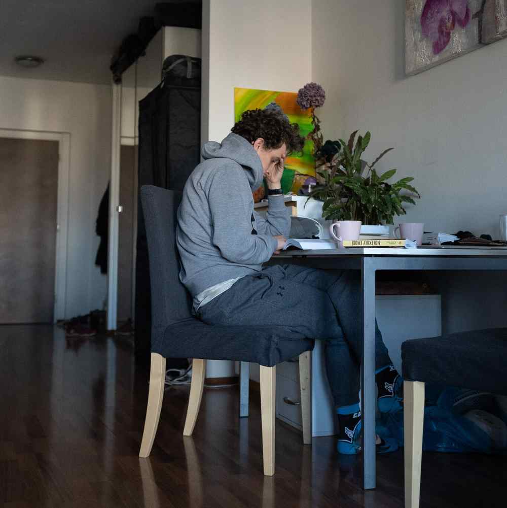 Muž pracuje u stolu v obývacím pokoji