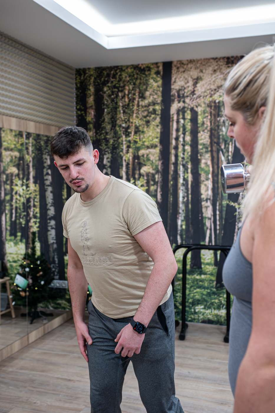 Trenér sleduje klientku při cviku