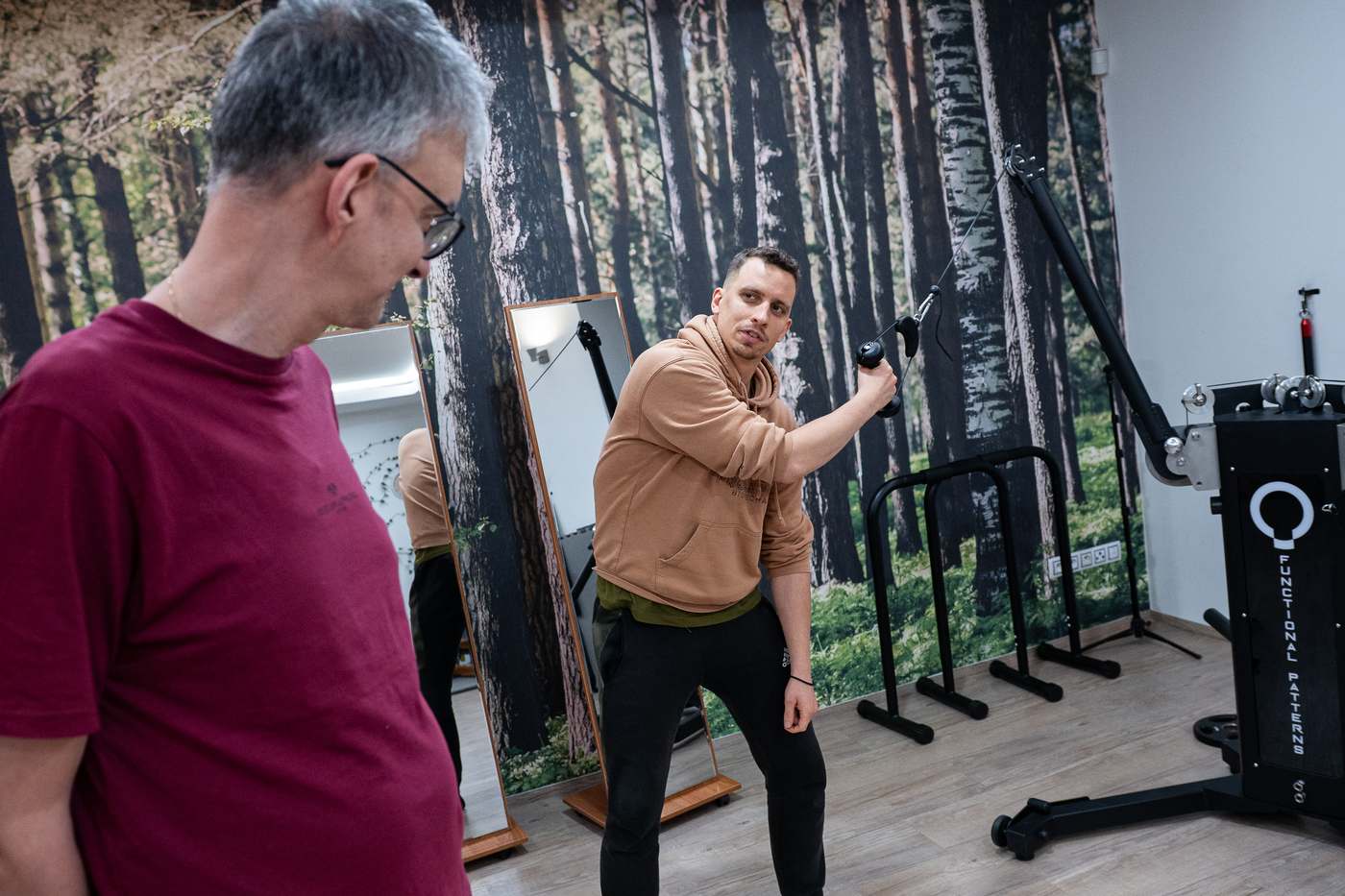 Trenér ukazuje klientovi provedení cviku